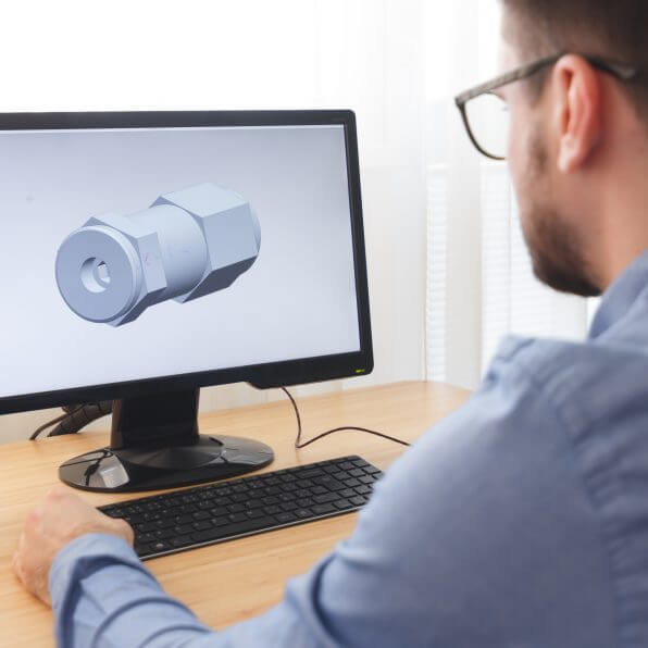 Engineer, Constructor, Designer in Glasses Working on a Personal Computer. He is Creating, Designing a New 3D Model of Mechanical Component in CAD Program. Freelance Work